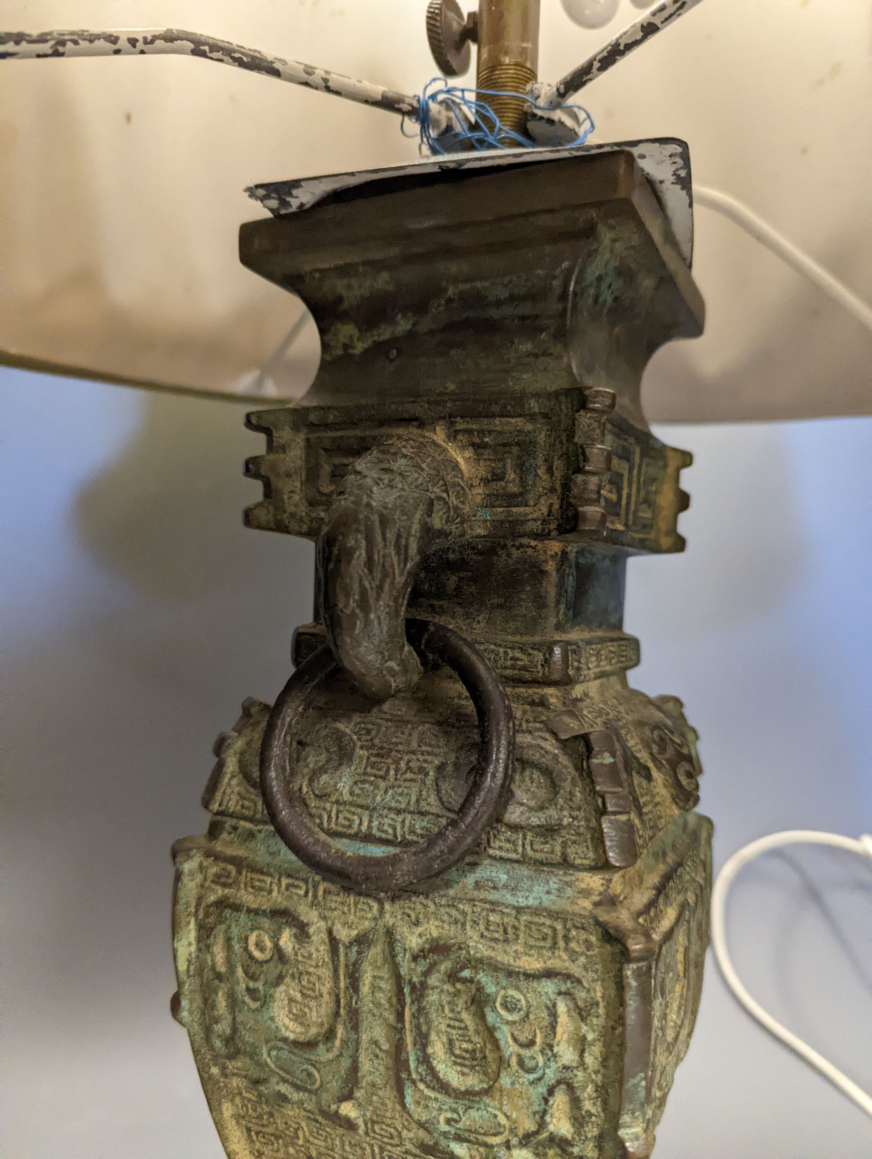 A pair of Chinese archaistic bronze lamps, 37 cms high not including shades or light fitting.